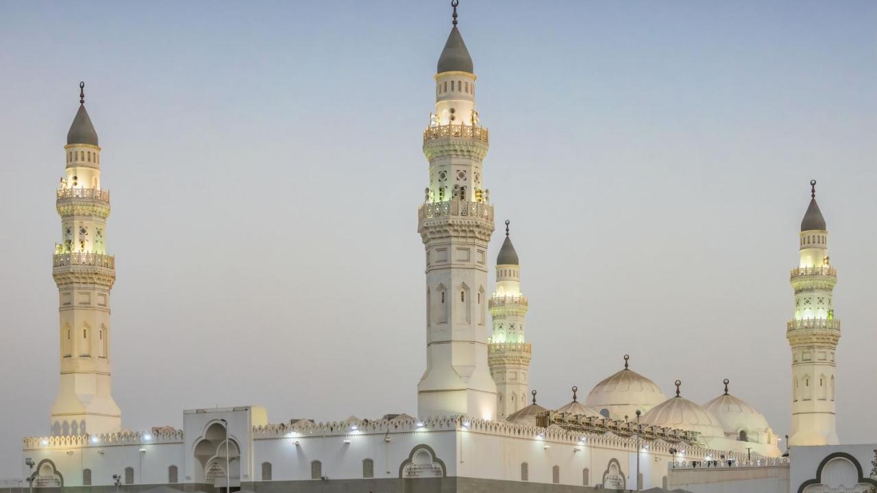 Готель Intercontinental Dar Al Iman Madinah By Ihg Medina Екстер'єр фото The image shows a mosque with distinct architectural features, including tall minarets and domes. The minarets are highlighted, likely lit up in the evening, showcasing intricate design elements typical of Islamic architecture. The overall scene conv