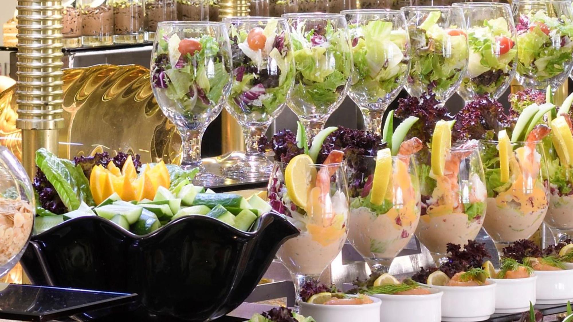 Готель Intercontinental Dar Al Iman Madinah By Ihg Medina Екстер'єр фото The photo features an elegant display of food items. In the background, there are several clear glasses filled with vibrant salads, featuring various types of greens and garnishes. In the foreground, there is a decorative black bowl containing cut pi