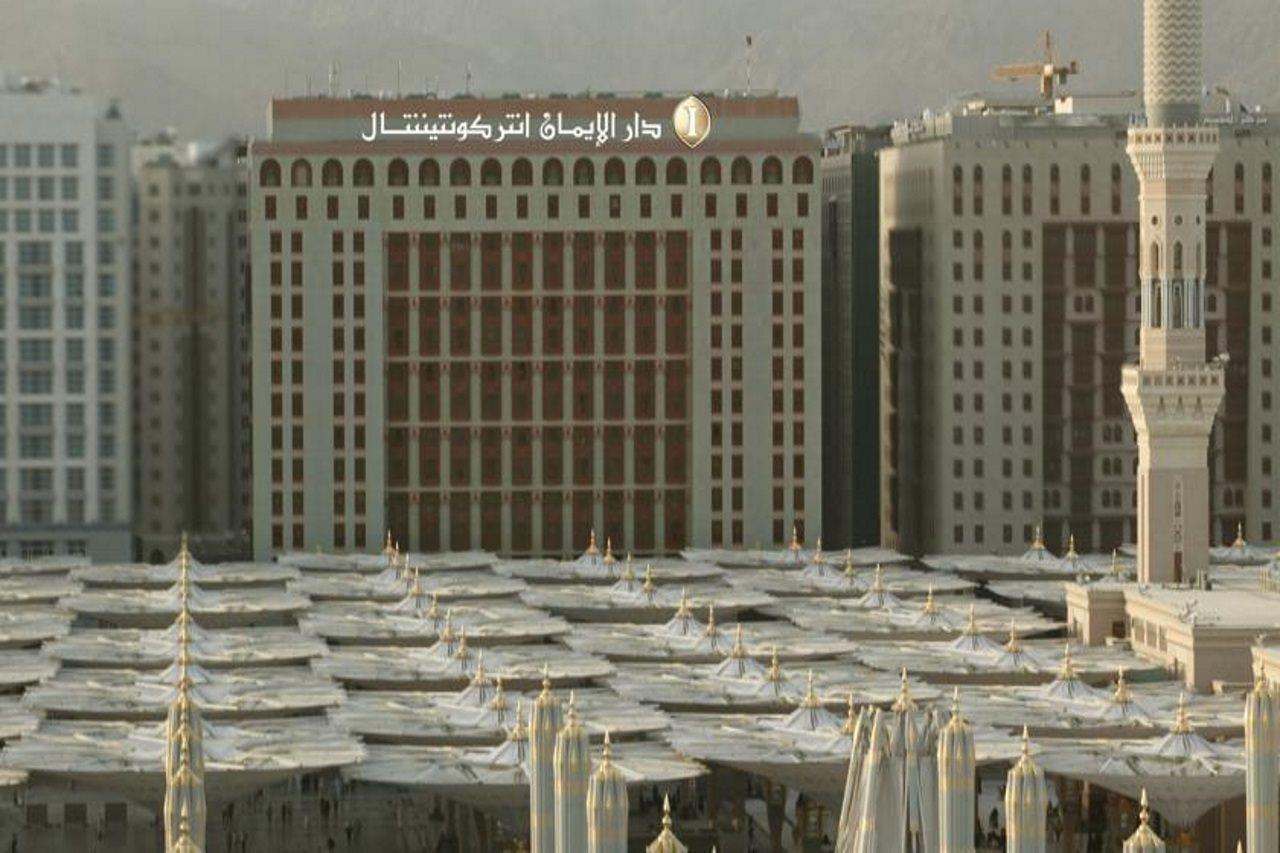 Готель Intercontinental Dar Al Iman Madinah By Ihg Medina Екстер'єр фото The photo shows a view of a large building with a modern architectural design, which appears to be a hotel or a commercial establishment. In front of the building, there are several large white canopies that provide shade, likely in a public space or